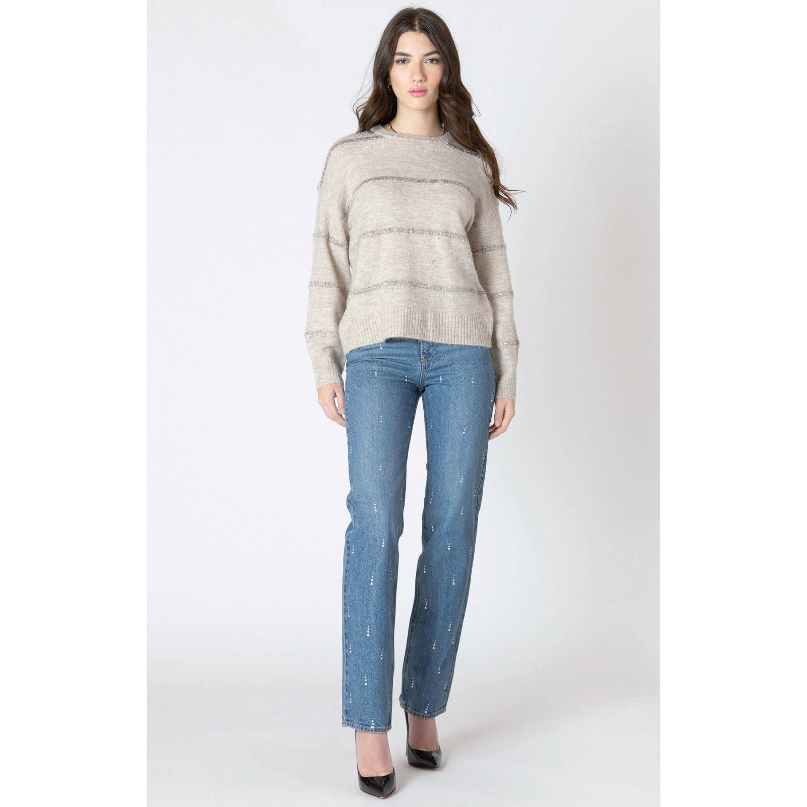 Beige Dex Sequin Stripe Sweater with shimmering horizontal stripes and long sleeves, styled with blue jeans.