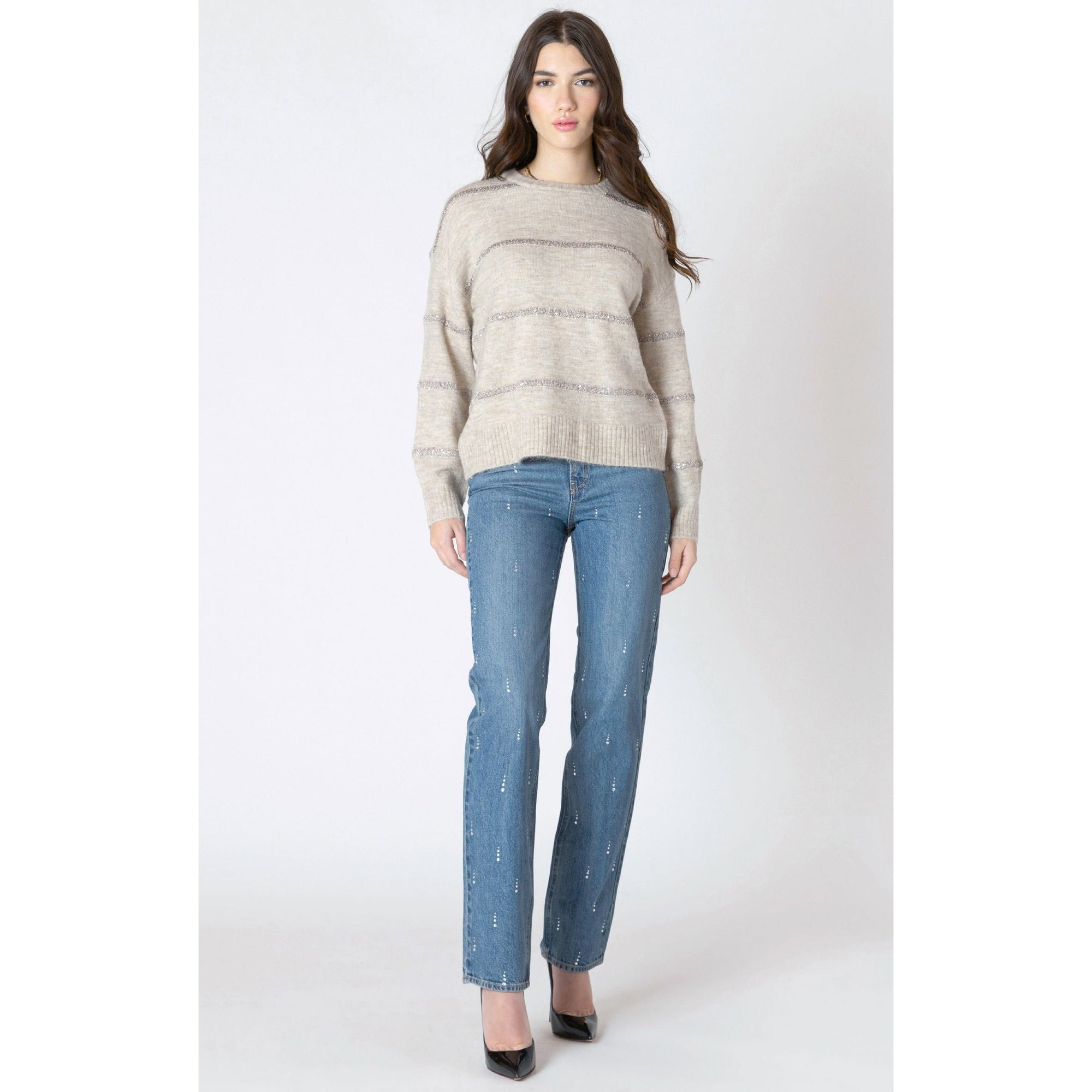 Beige Dex Sequin Stripe Sweater with shimmering horizontal stripes and long sleeves, styled with blue jeans.
