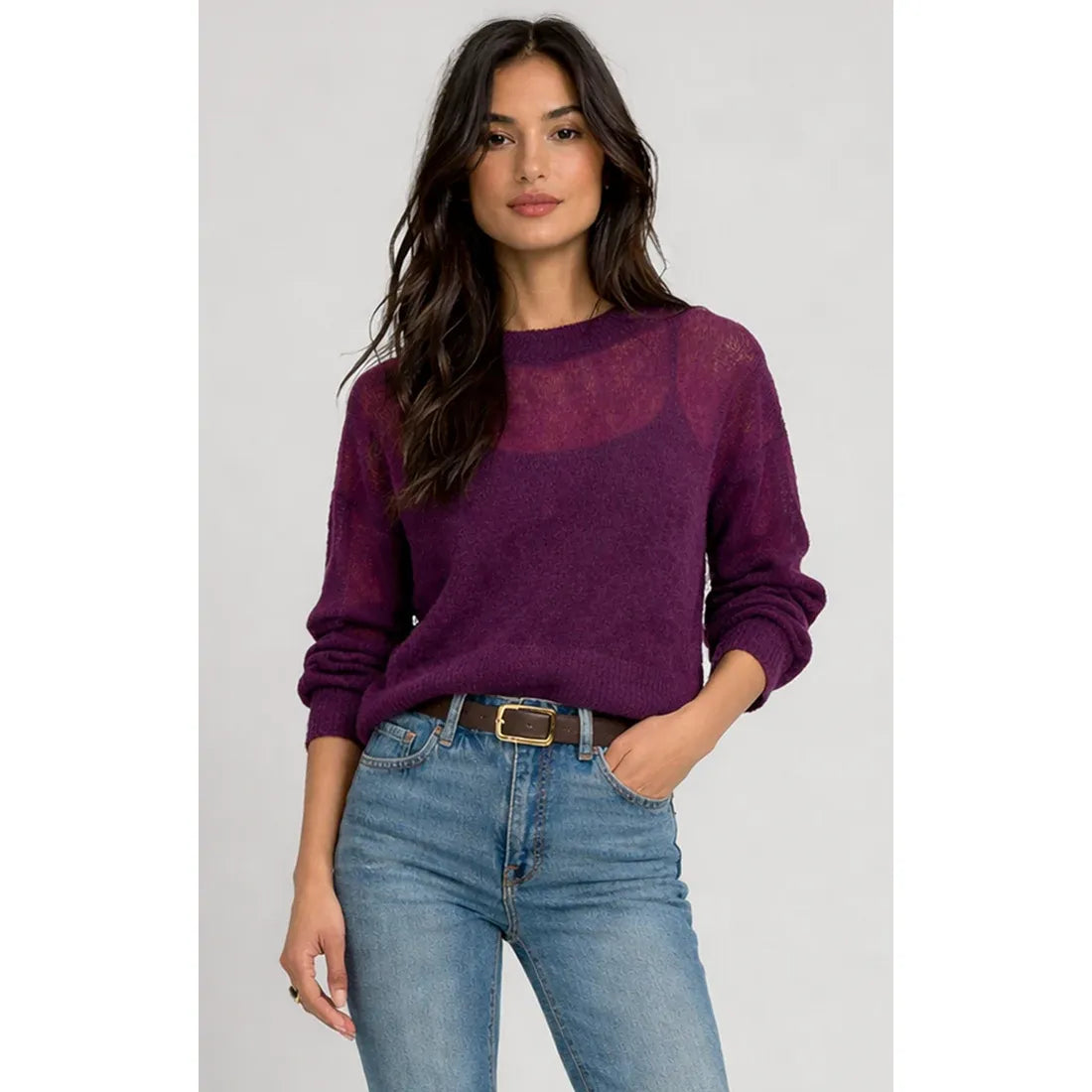 Purple sheer knit sweater top with semi-sheer chest panel layered over a camisole, styled with blue jeans and a brown belt.