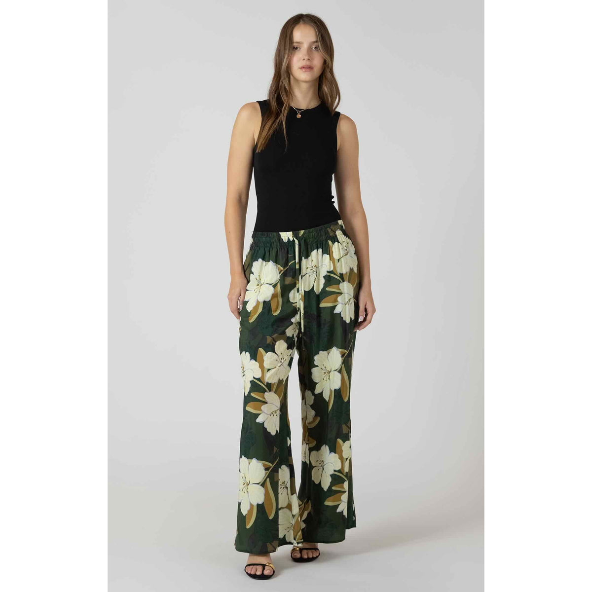Dex Wide Leg Flowy Pants in green floral print with a relaxed, draped silhouette, paired with a black sleeveless top.