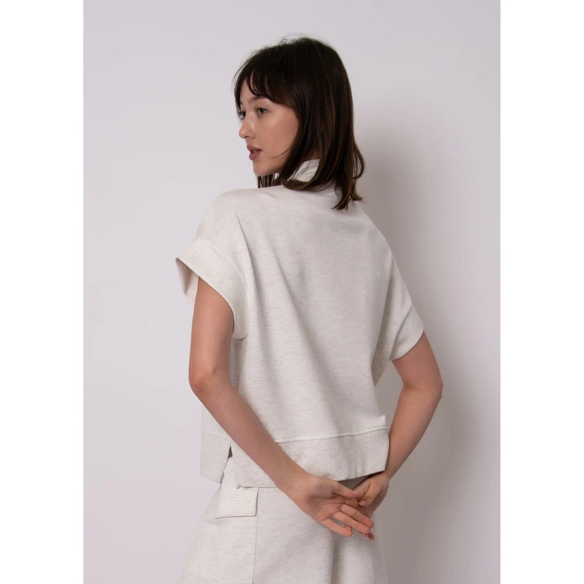 Model wearing light heather Dua Soft Knit 1/2 Zip Top with short-cuffed sleeves.