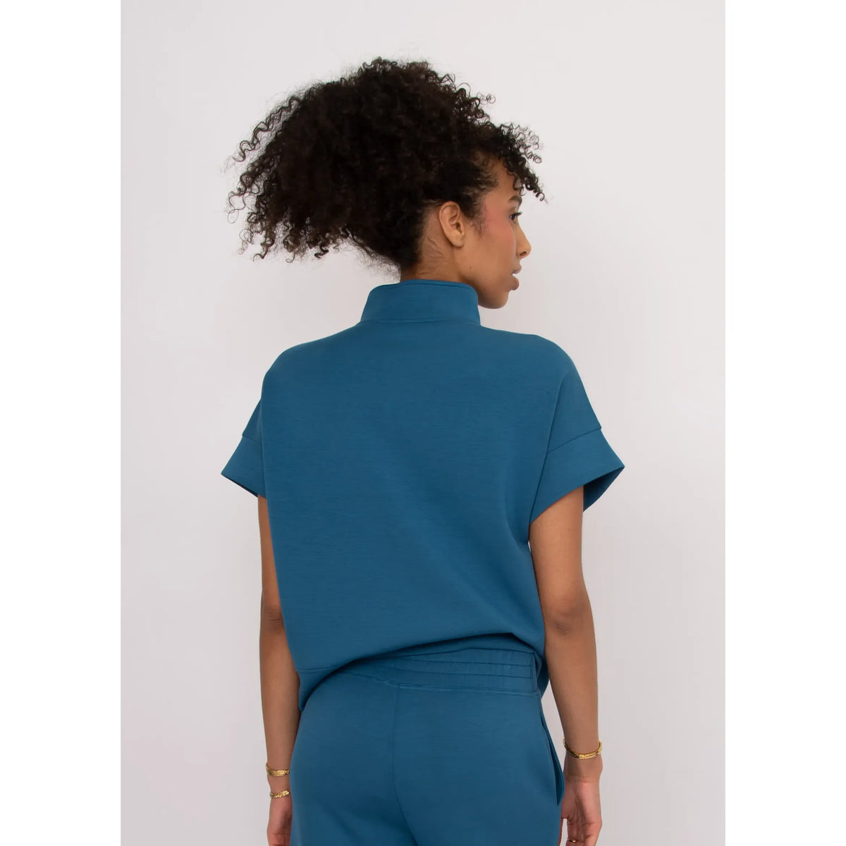 Dua Soft Knit 1/2 Zip Top in teal, back view with short cuffed sleeves and a relaxed breezy fit.