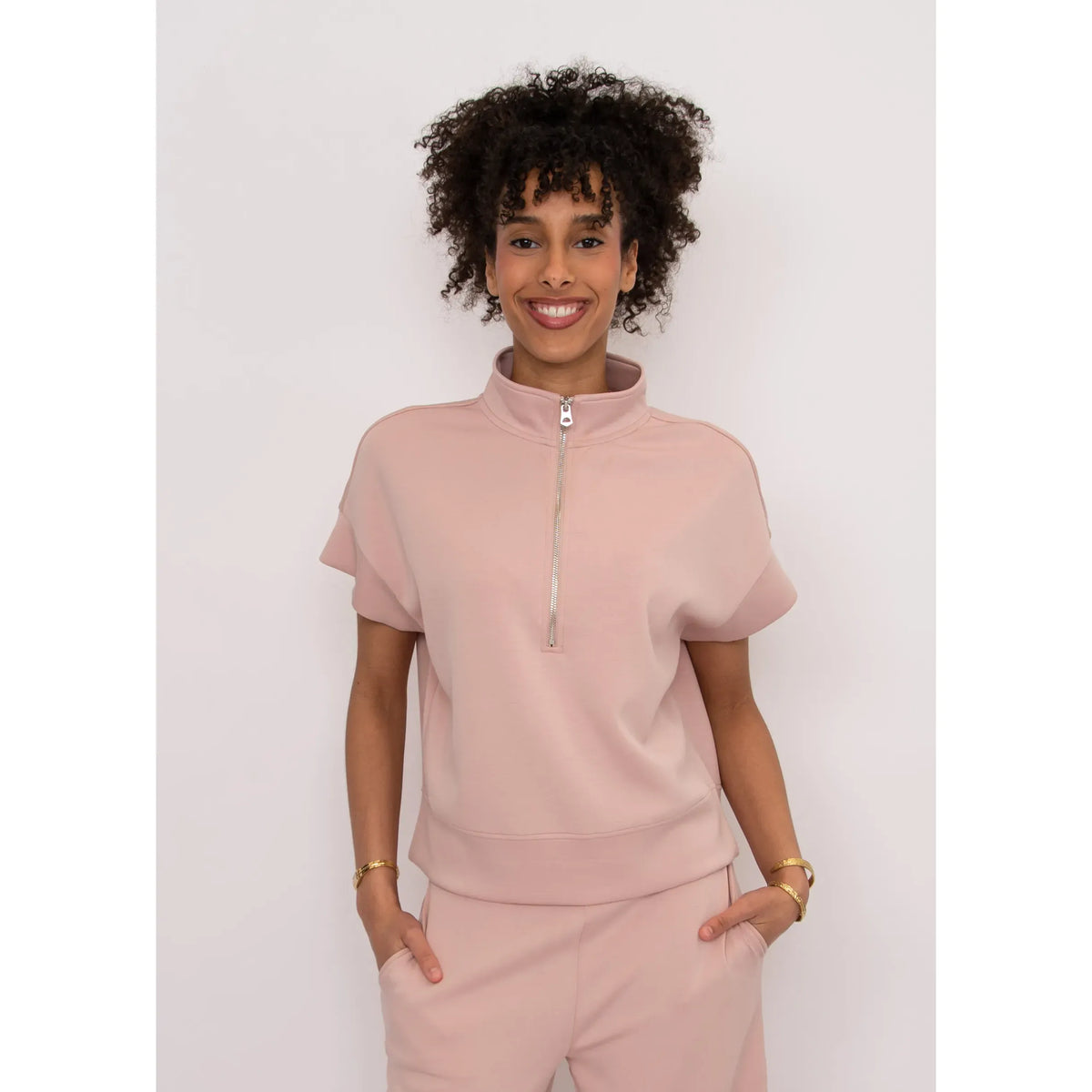 Dua Soft Knit 1/2 Zip Top in blush pink with front zip, short cuffed sleeves, and relaxed fit.
