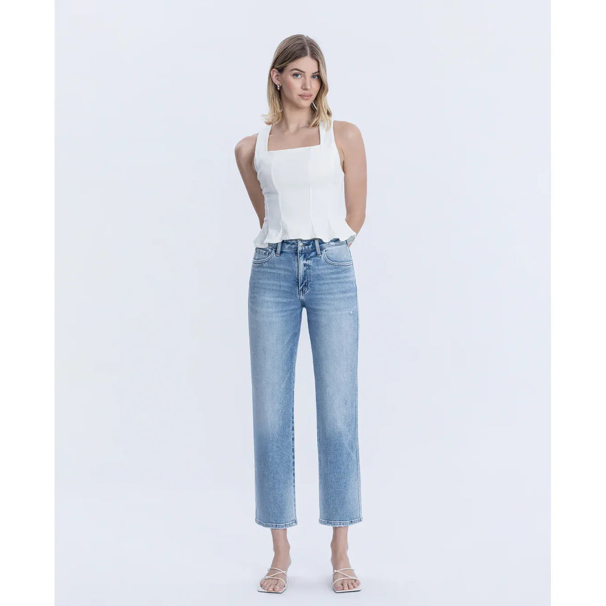 Model wearing Blissful Symphony High Rise Ankle Straight jeans in light-wash stretch denim.