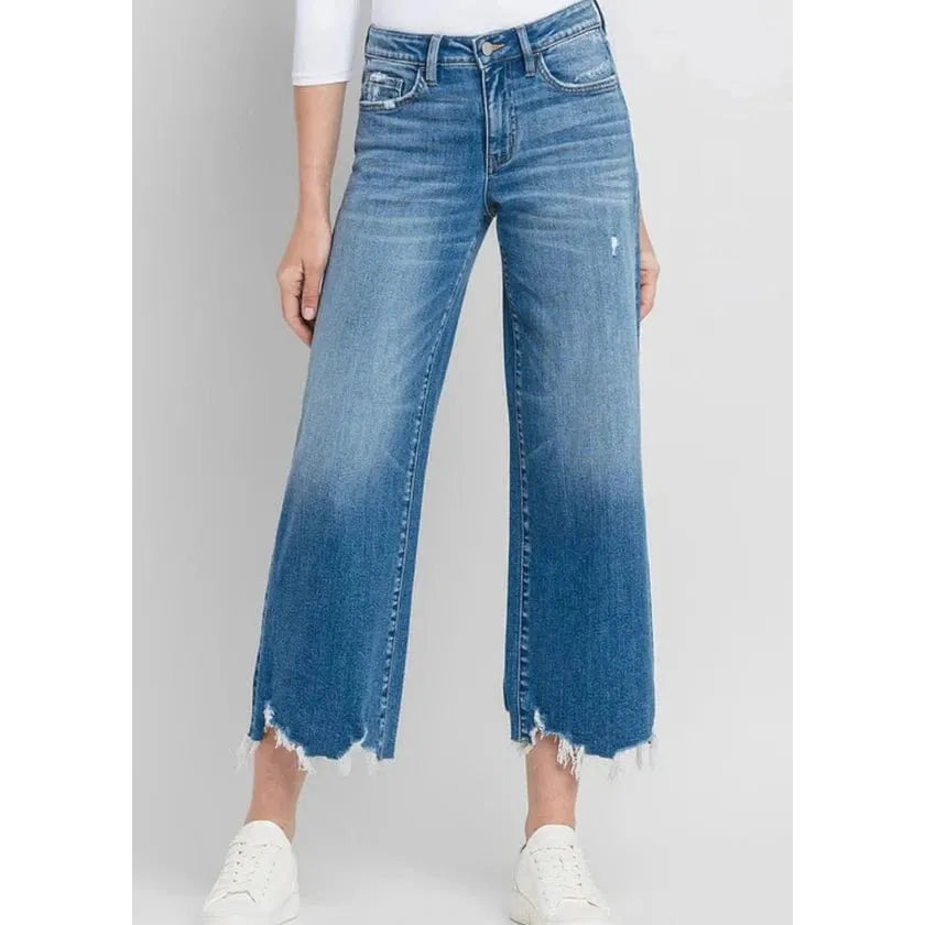Stylish woman wearing Flying Monkey Delightful High Rise Crop Wide Leg Denim with distressed hem and medium wash.