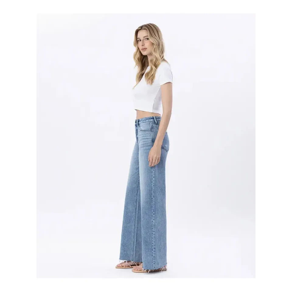 Stylish model showcasing the Flying Monkey Modernity Raw Hem High Rise Wide Leg jeans with a flattering silhouette.