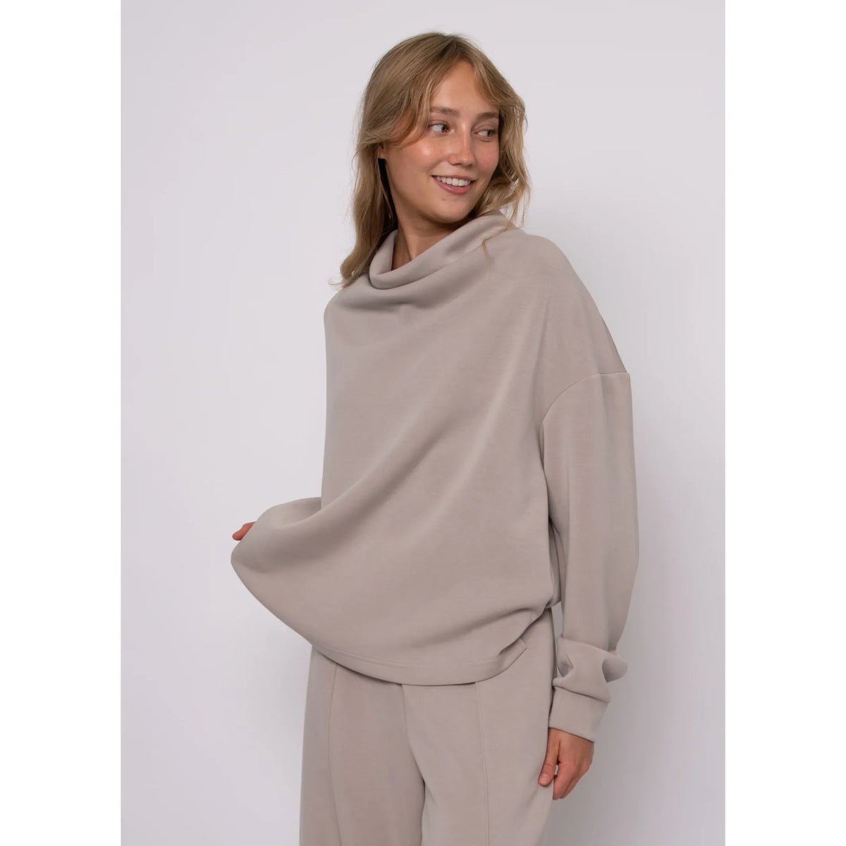 Beige soft knit funnel neck top with long sleeves and cozy stand-up neckline for refined everyday style.