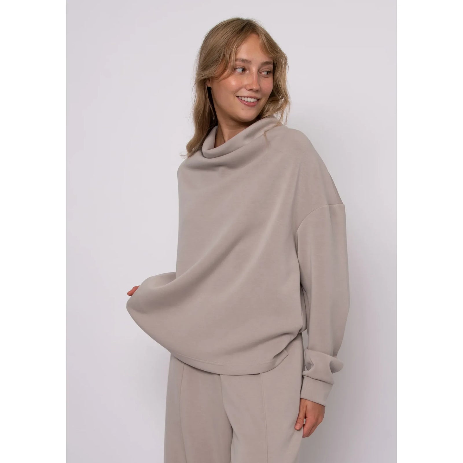 Beige soft knit funnel neck top with long sleeves and cozy stand-up neckline for refined everyday style.