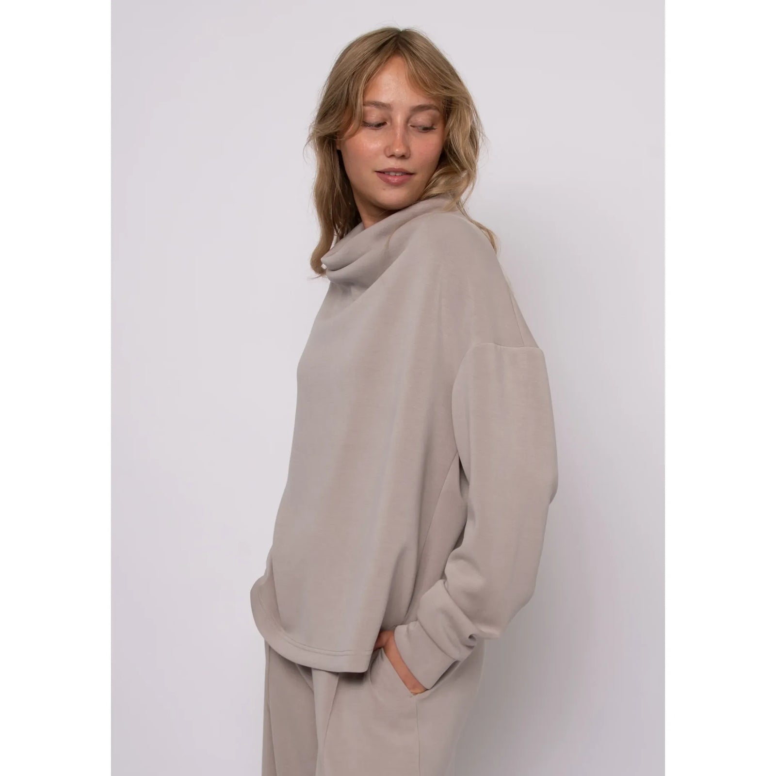 Beige soft knit funnel neck top with a cozy stand-up collar and relaxed long sleeves for everyday style.