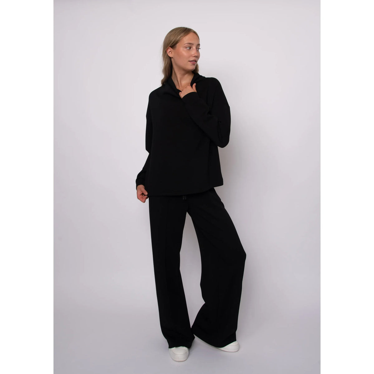Black soft knit funnel neck top with long sleeves and a cozy stand-up collar for effortless everyday comfort.