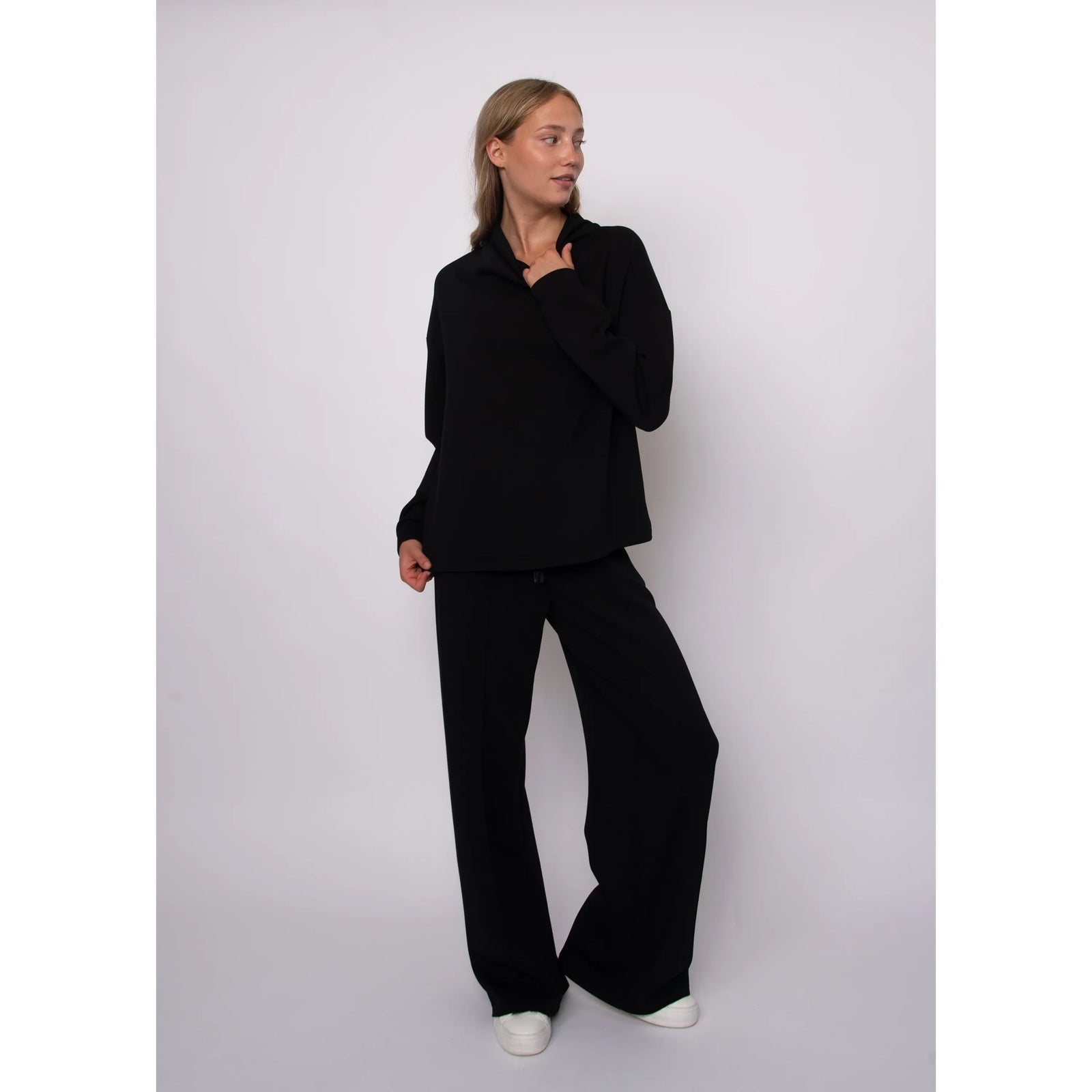 Black soft knit funnel neck top with long sleeves and a cozy stand-up collar for effortless everyday comfort.