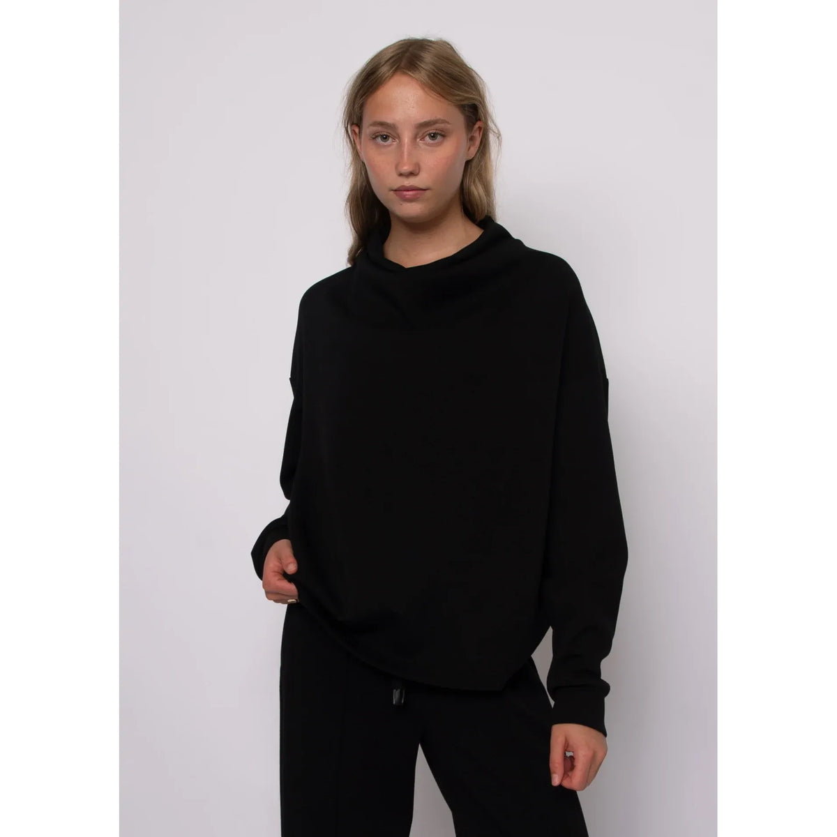Black soft knit funnel neck top with long sleeves and cozy stand-up collar for effortless everyday style.