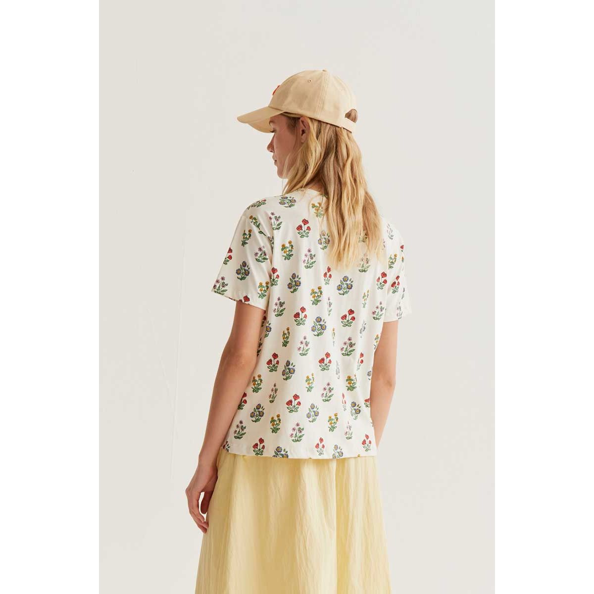 Gardener Print Tee featuring a whimsical multicoloured botanical print, back view on a model.