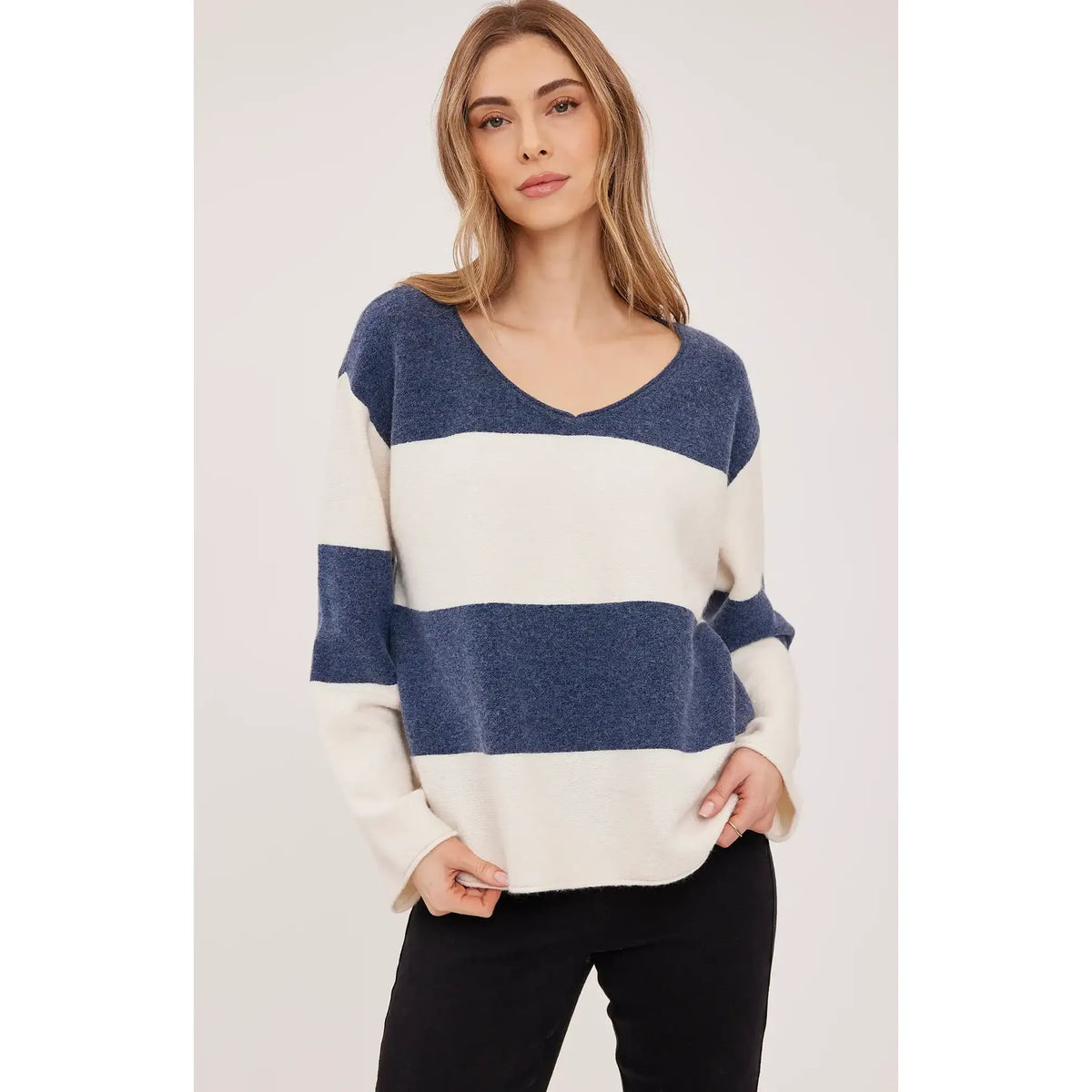 Oversized blue and cream striped V-neck sweater with soft textured knit and rolled edges for cozy comfort.