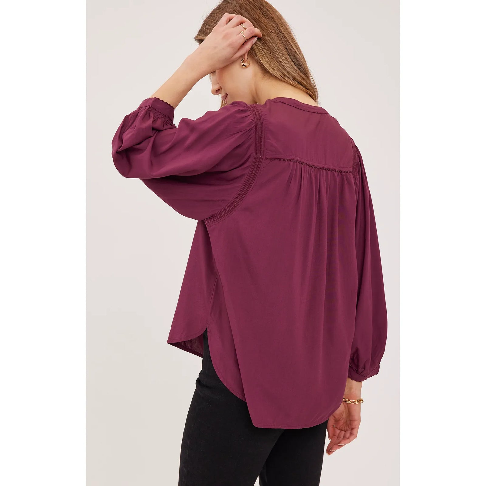 Back view of a burgundy Ashlyn blouse featuring delicate lace trim, gathered sleeves, and a soft viscose drape.