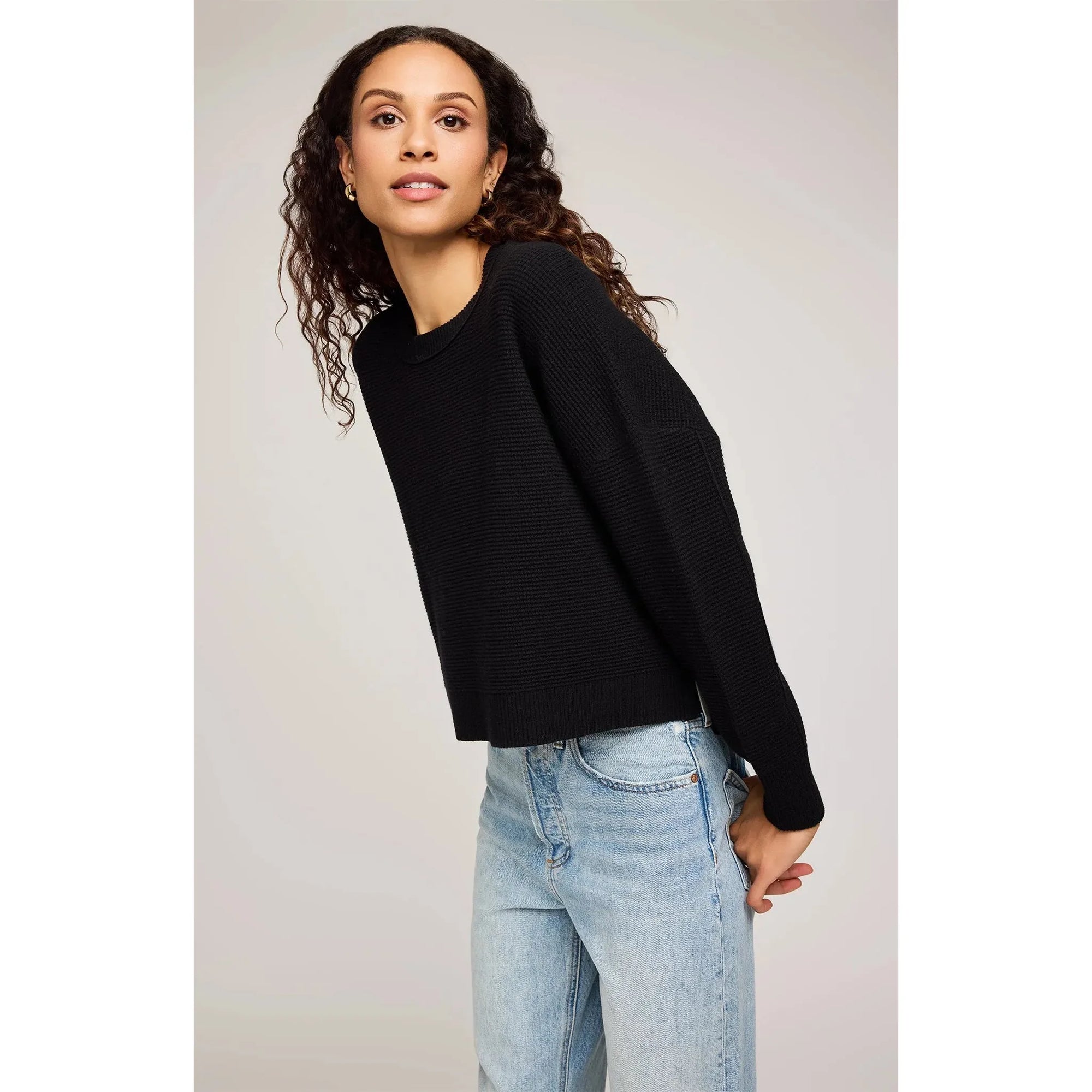 Gentle Fawn Axel Crewneck Sweater on a model in black knit, oversized with side slits.