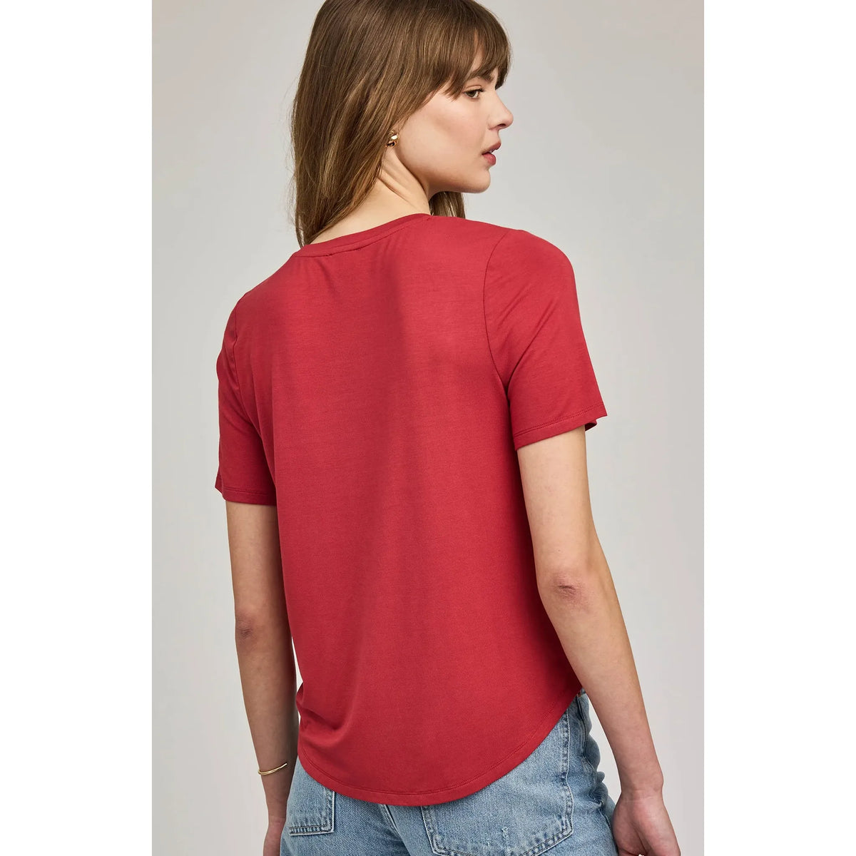 Back view of red Brielle TShirt on model, relaxed fit with curved hem, paired with jeans.