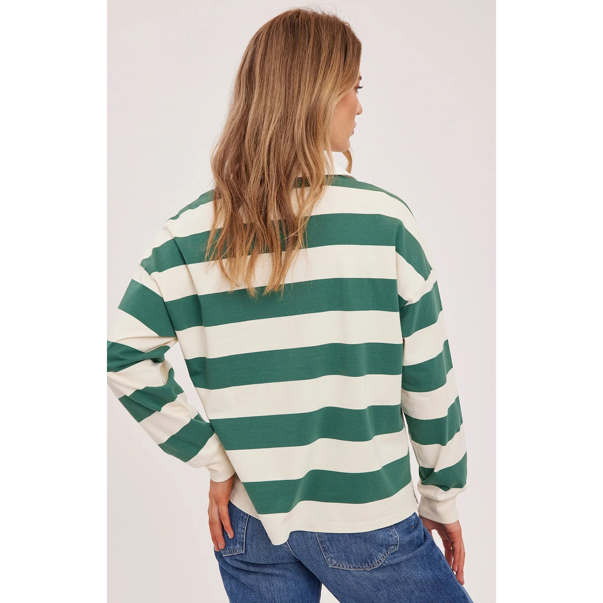 Back view of a model wearing a Gentle Fawn Britt Rugby Shirt in green and white stripes with a white collar.