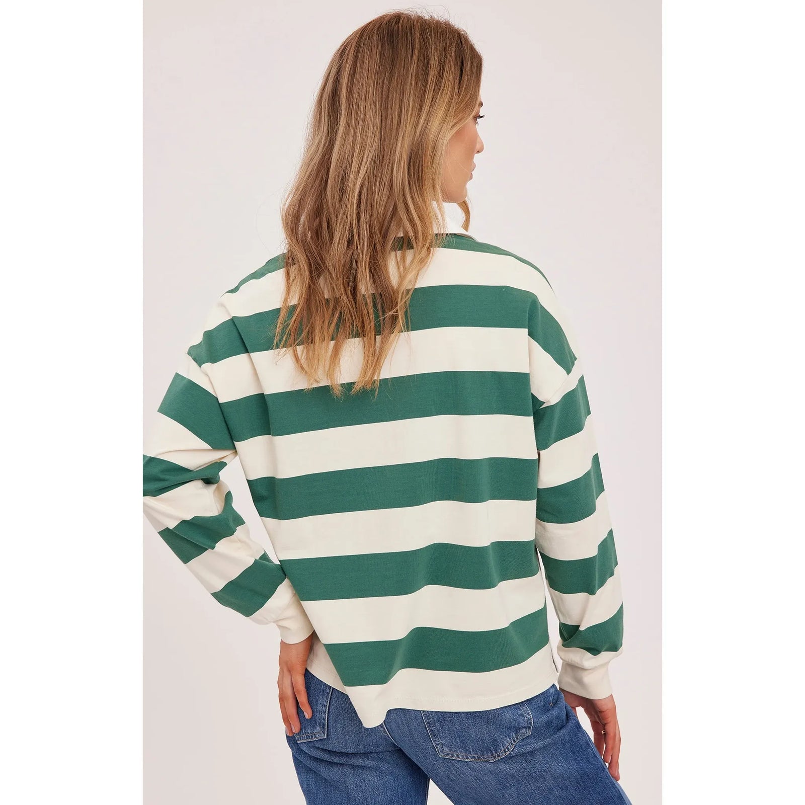 Back view of a model wearing a Gentle Fawn Britt Rugby Shirt in green and white stripes with a white collar.
