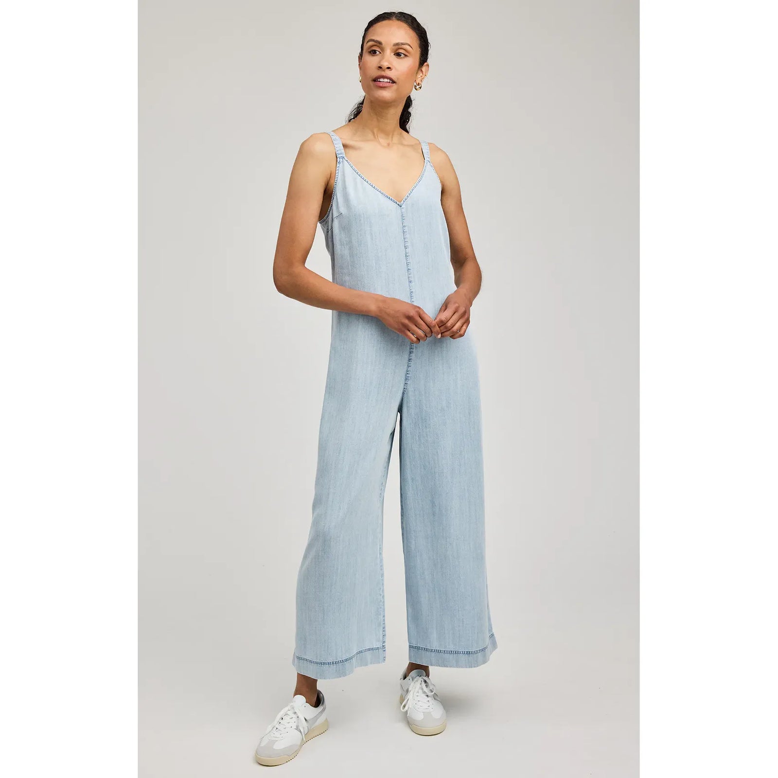 Cambry Jumpsuit in light denim with V-neck, thin straps, and wide-leg silhouette on a model.