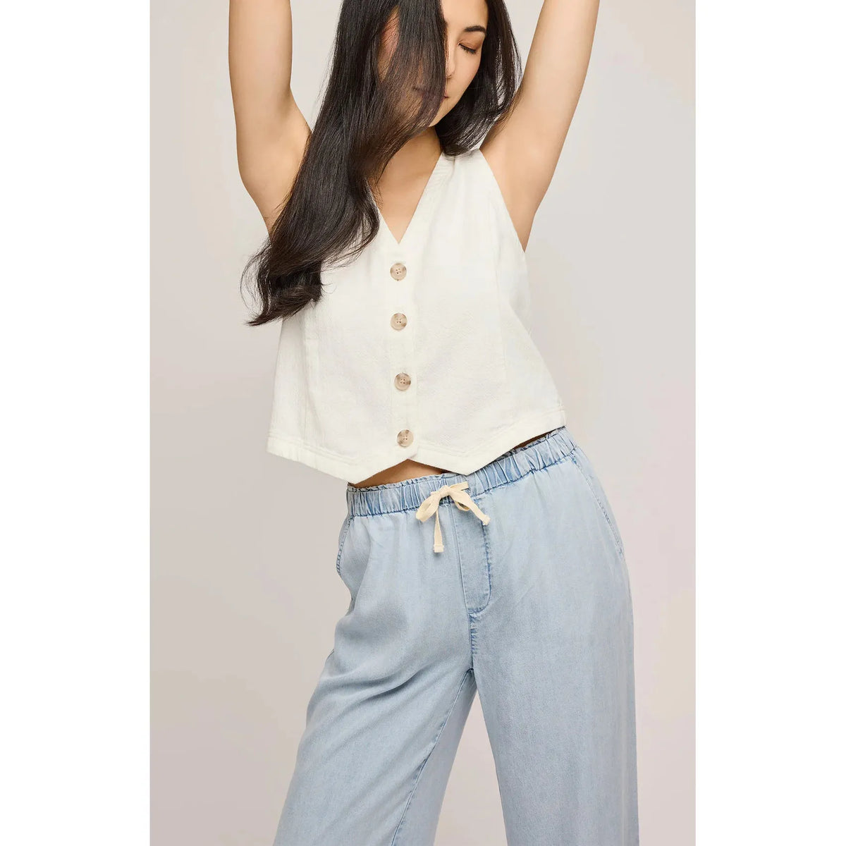 Stylish model showcases the Gentle Fawn Elio Pant in light blue, featuring soft Tencel fabric and an elastic waistband.