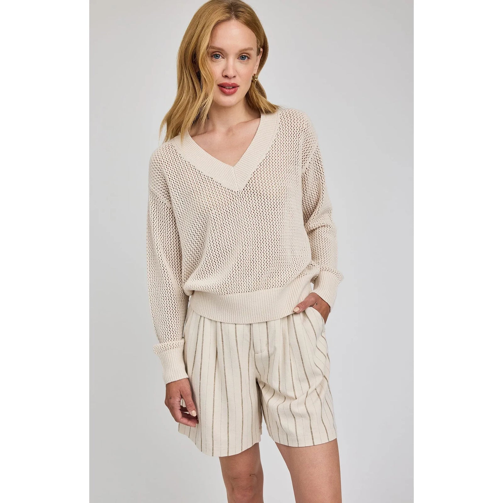 Gentle Fawn Jensen V-Neck Pullover in beige open-knit with relaxed fit, shown with striped shorts.