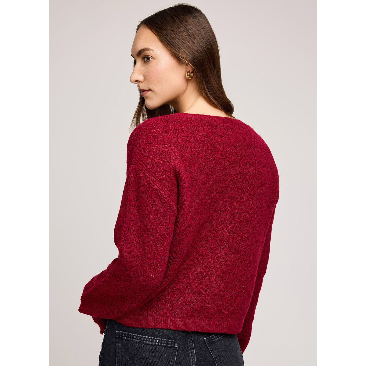 Model wearing burgundy Gentle Fawn Lila Cardigan with soft yarn and pointelle knit, back view.
