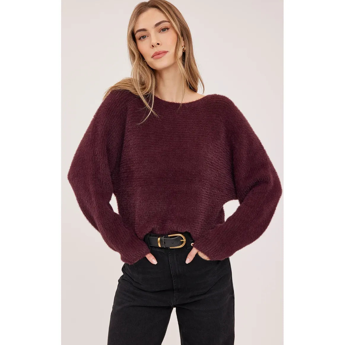 Plush deep Port boatneck sweater with dolman sleeves and chunky knit texture, styled with black denim and a belt.