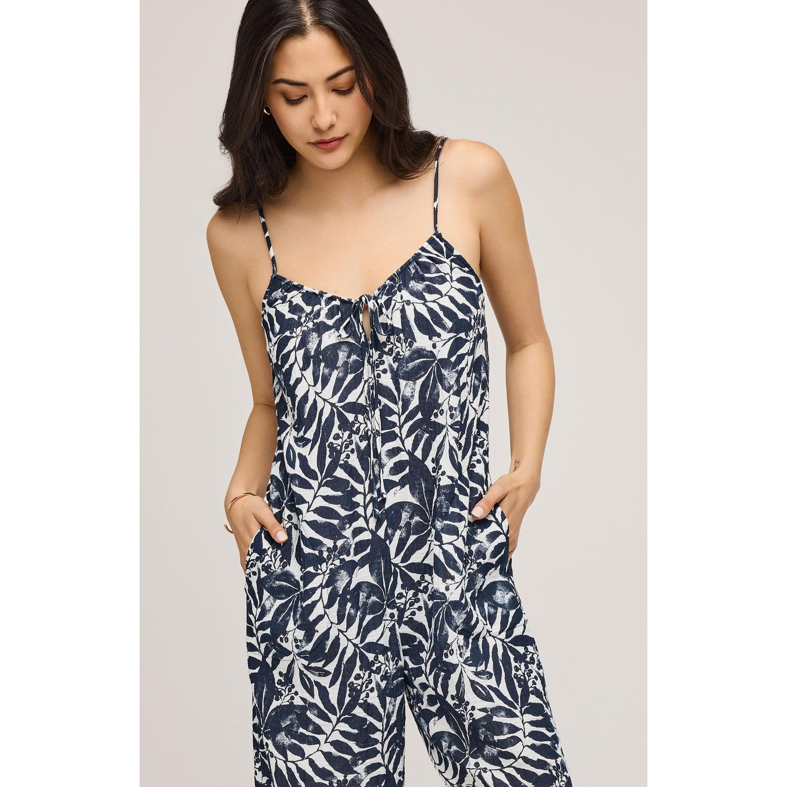 Stylish woman wearing the Gentle Fawn Matilda Jumpsuit with adjustable straps and elegant floral design.