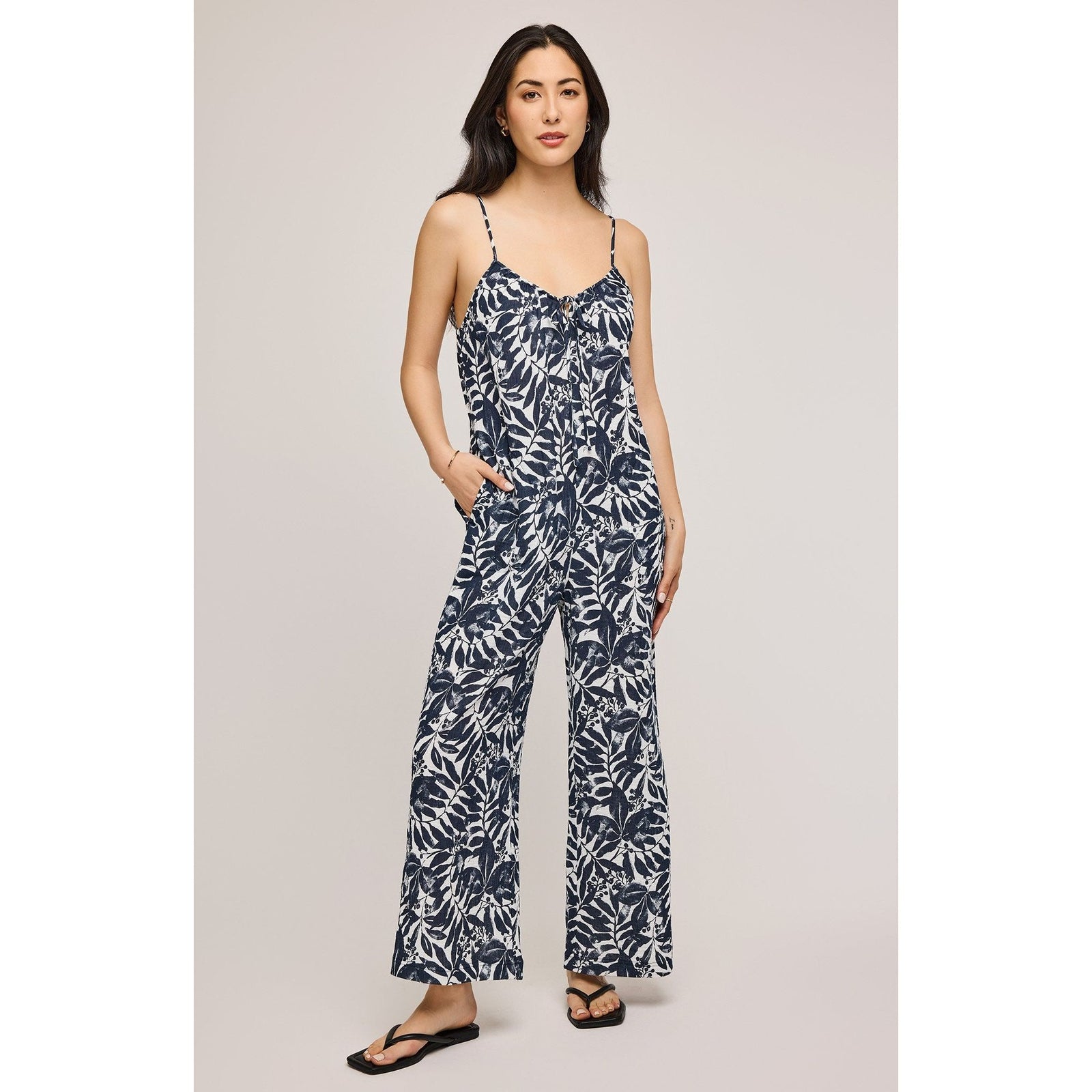 Stylish woman wearing the Gentle Fawn Matilda Jumpsuit, featuring adjustable straps and a floral print for summer elegance.
