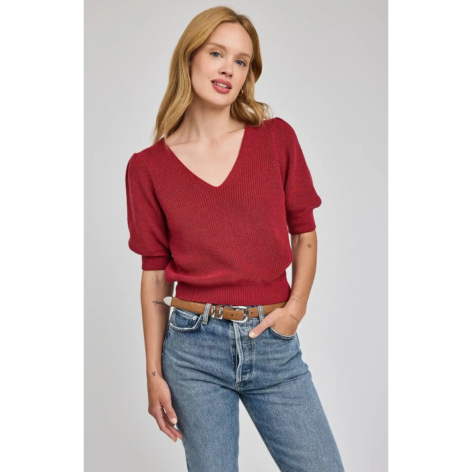 Gentle Fawn Phoebe V-Neck Sweater in deep red with puff sleeves, worn by a model in denim jeans.
