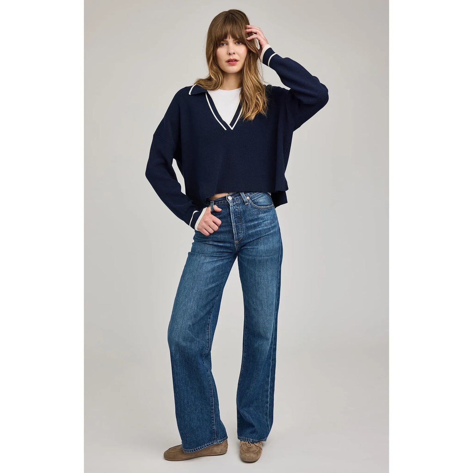 Gentle Fawn Tristan V-Neck Sweater in navy with white stripe trim at the V-neck and cuffs, worn with jeans.