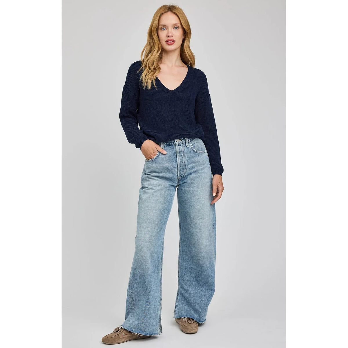 Gentle Fawn Tucker Pullover navy V-neck knit sweater on model with wide-leg denim jeans.