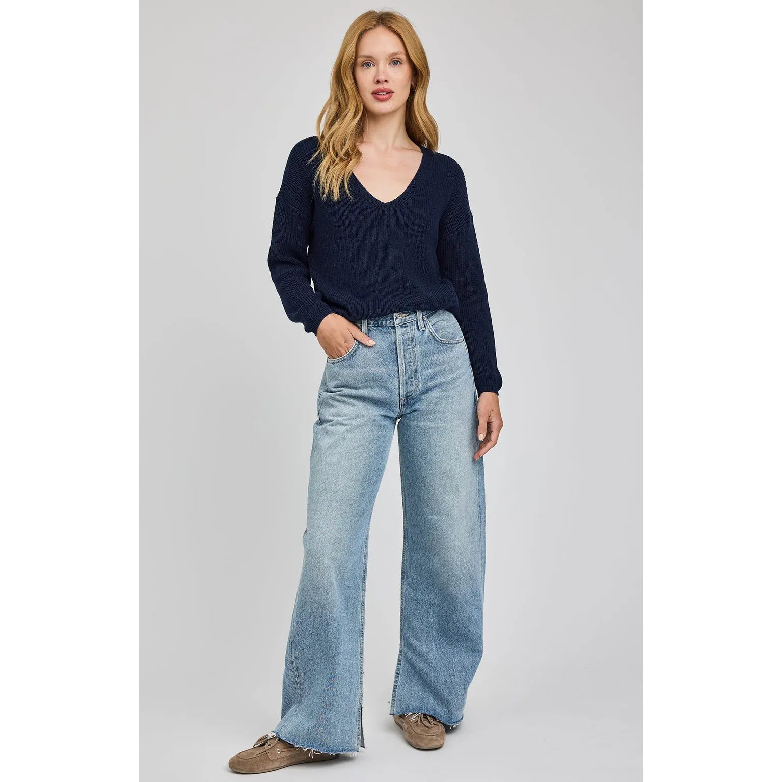 Gentle Fawn Tucker Pullover navy V-neck knit sweater on model with wide-leg denim jeans.