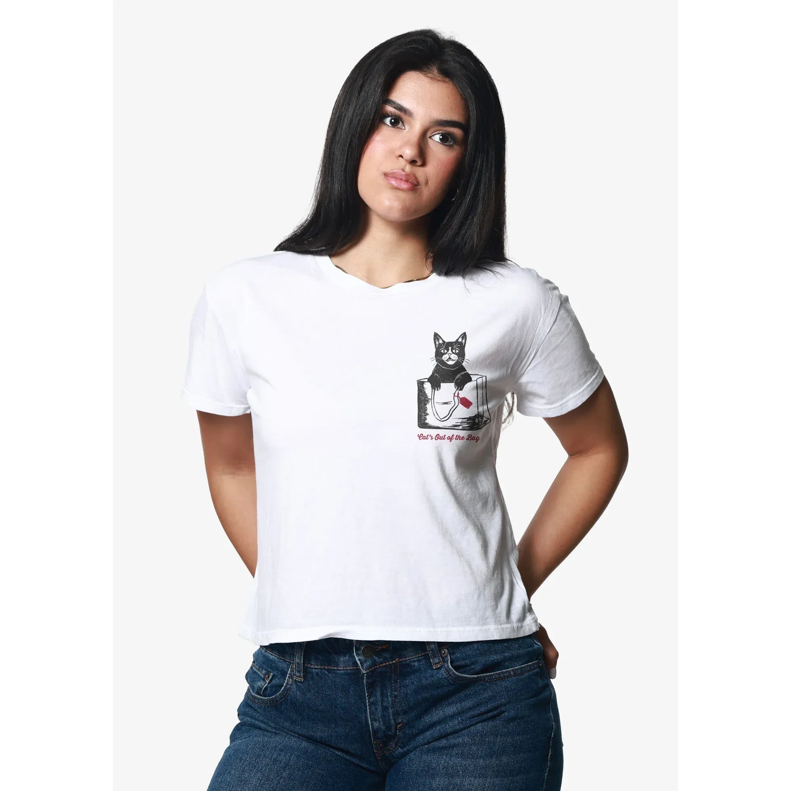 White pigment-dyed cotton tee with a black cat in a bag and red 'Cat's Out of the Bag' text.