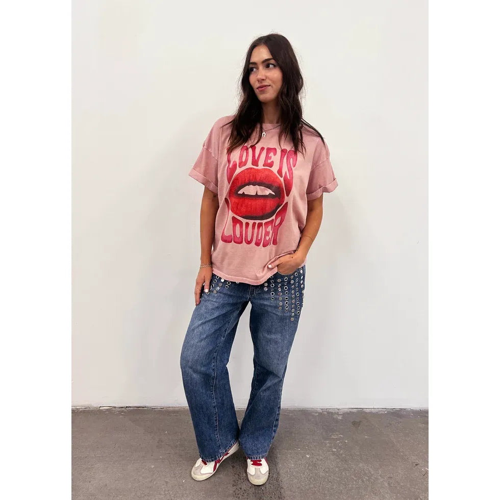 Pink oversized boyfriend tee with Love Is Louder lip graphic worn by a model.
