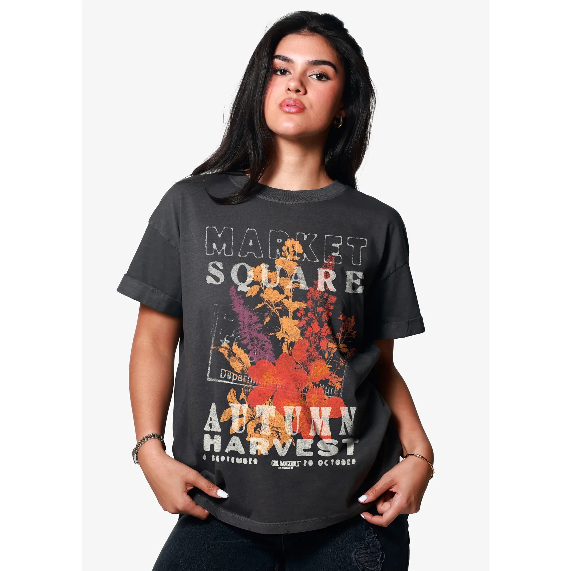 Young woman wearing black oversized boyfriend tee with Market Square Autumn Harvest floral graphic.