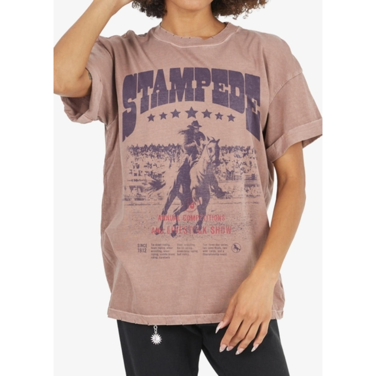 Girl wearing oversized pink Stampede Poster Boyfriend Tee in vintage sun-washed cotton.