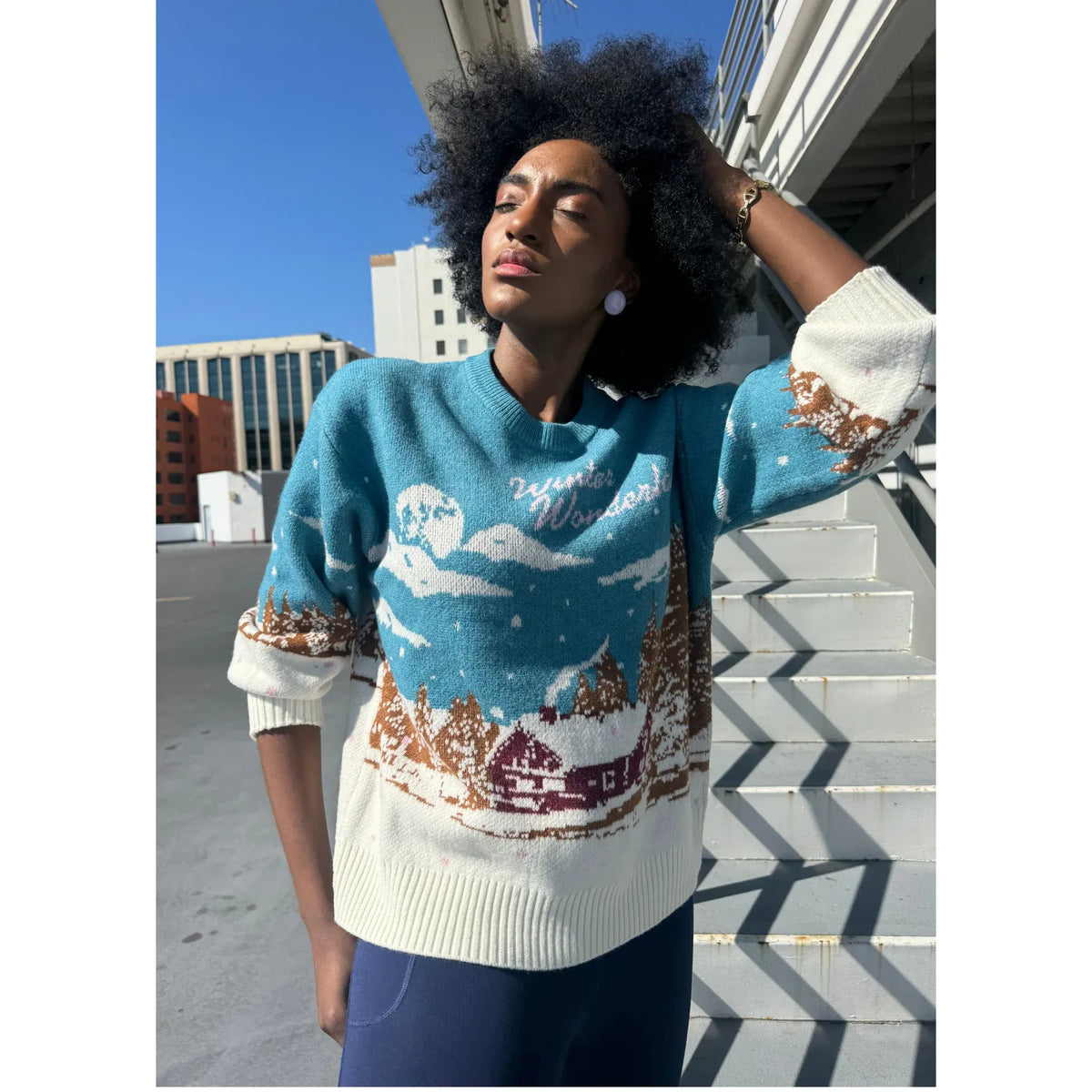 Girl Dangerous Alpine Club oversized sweater with alpine village print in blue and white, cozy chunky knit.