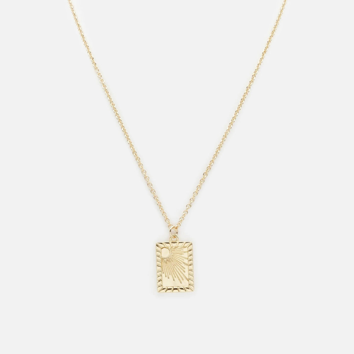 Gold necklace with a rectangular sun-motif pendant on a delicate chain.