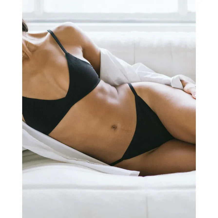 Huha String Thong Mineral Undies by Huha, model in black seamless thong with seam-free gusset and zinc-oxide liner.