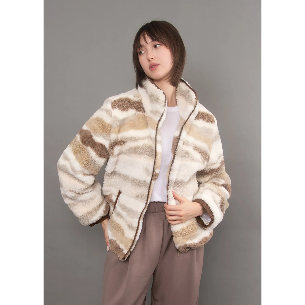 Plush patterned sherpa jacket with brown and cream stripes, featuring a full zip, velvet trim details, and an easy casual silhouette.