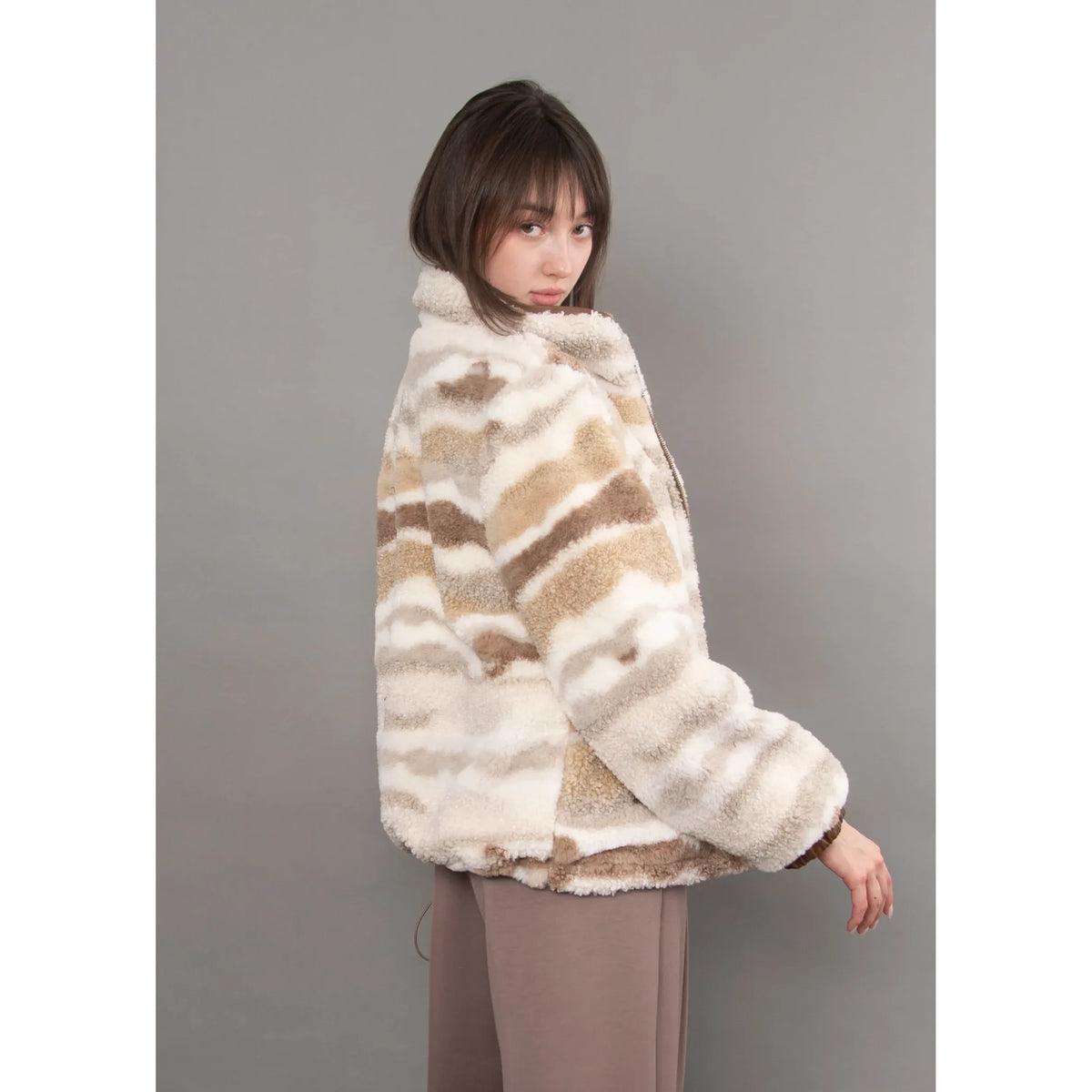 Plush striped sherpa jacket in brown and cream tones with a full zip closure and relaxed, cozy silhouette.