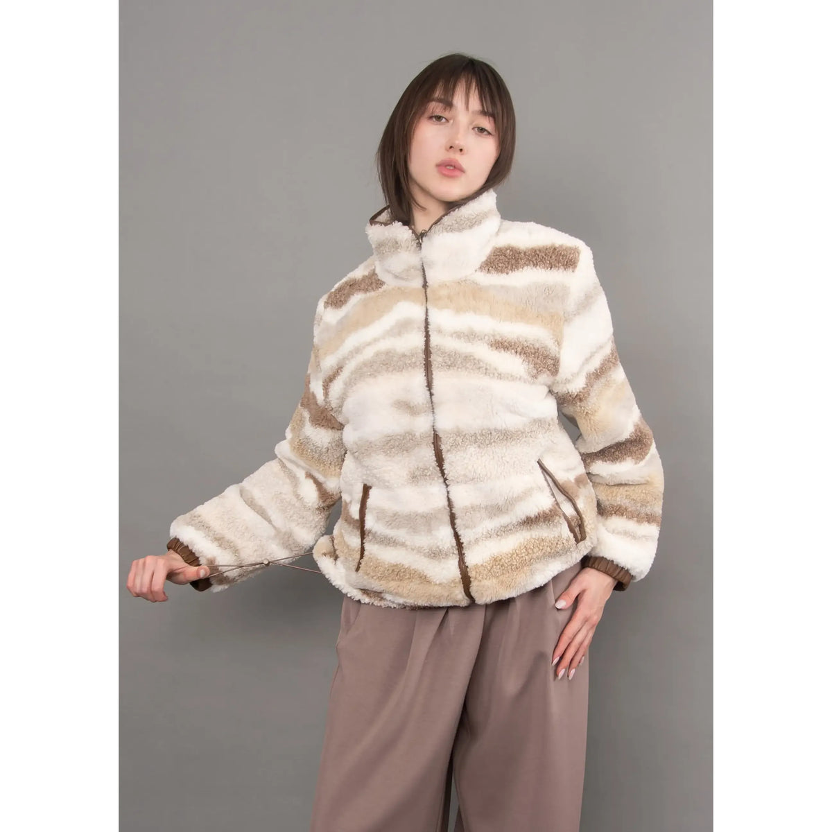 Striped beige and cream full-zip sherpa jacket with brown trim details, featuring a cozy plush texture and casual silhouette.