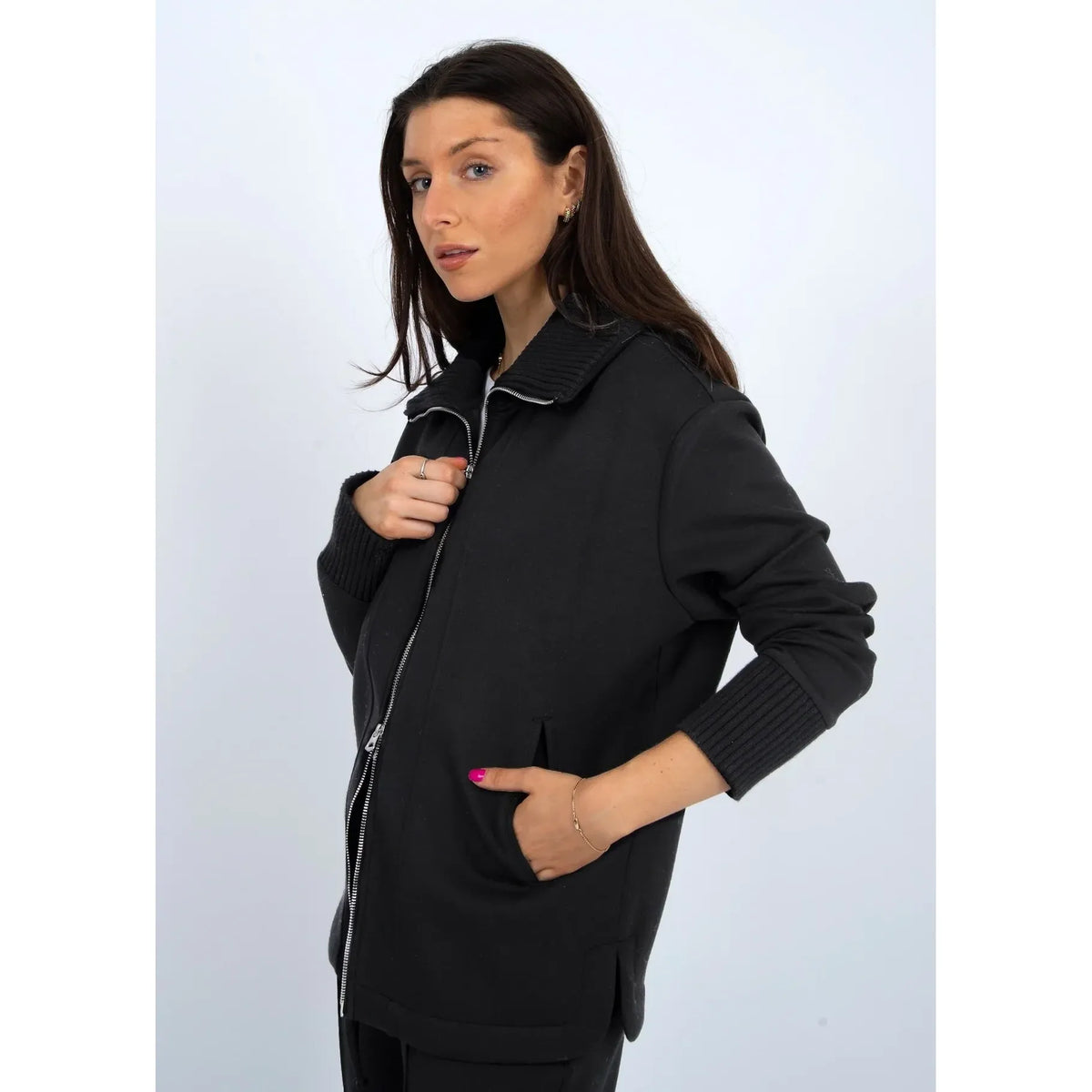 Model wearing Judia Soft Knit Zip Sweater in black, oversized with two-way zipper, ribbed collar and cuffs.