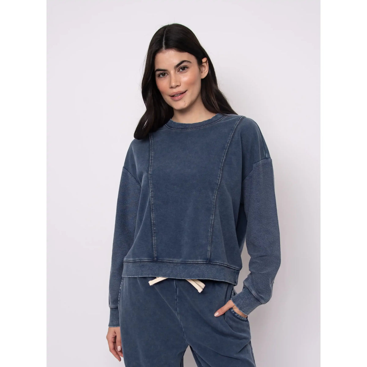 Model wearing Kacey French Terry Pull Over Crew Top in washed blue with relaxed silhouette and matching joggers.