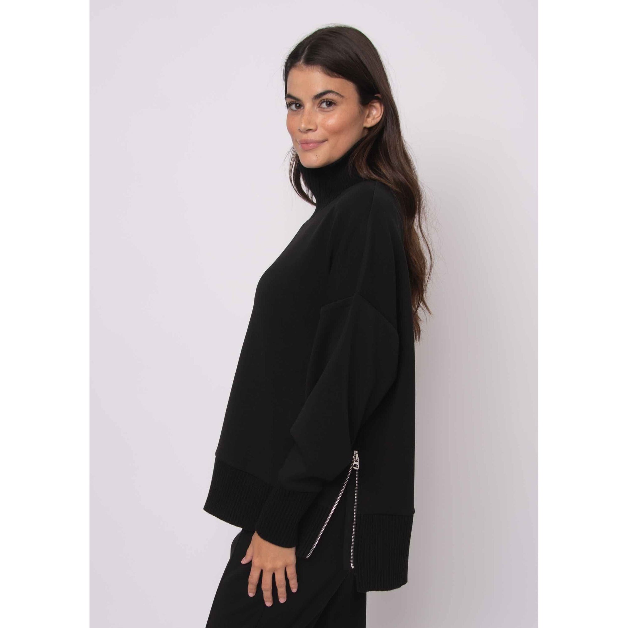 Katelyn Soft Knit Sweater on a model: oversized black knit with ribbed cuffs, cowl neck, and side zipper.