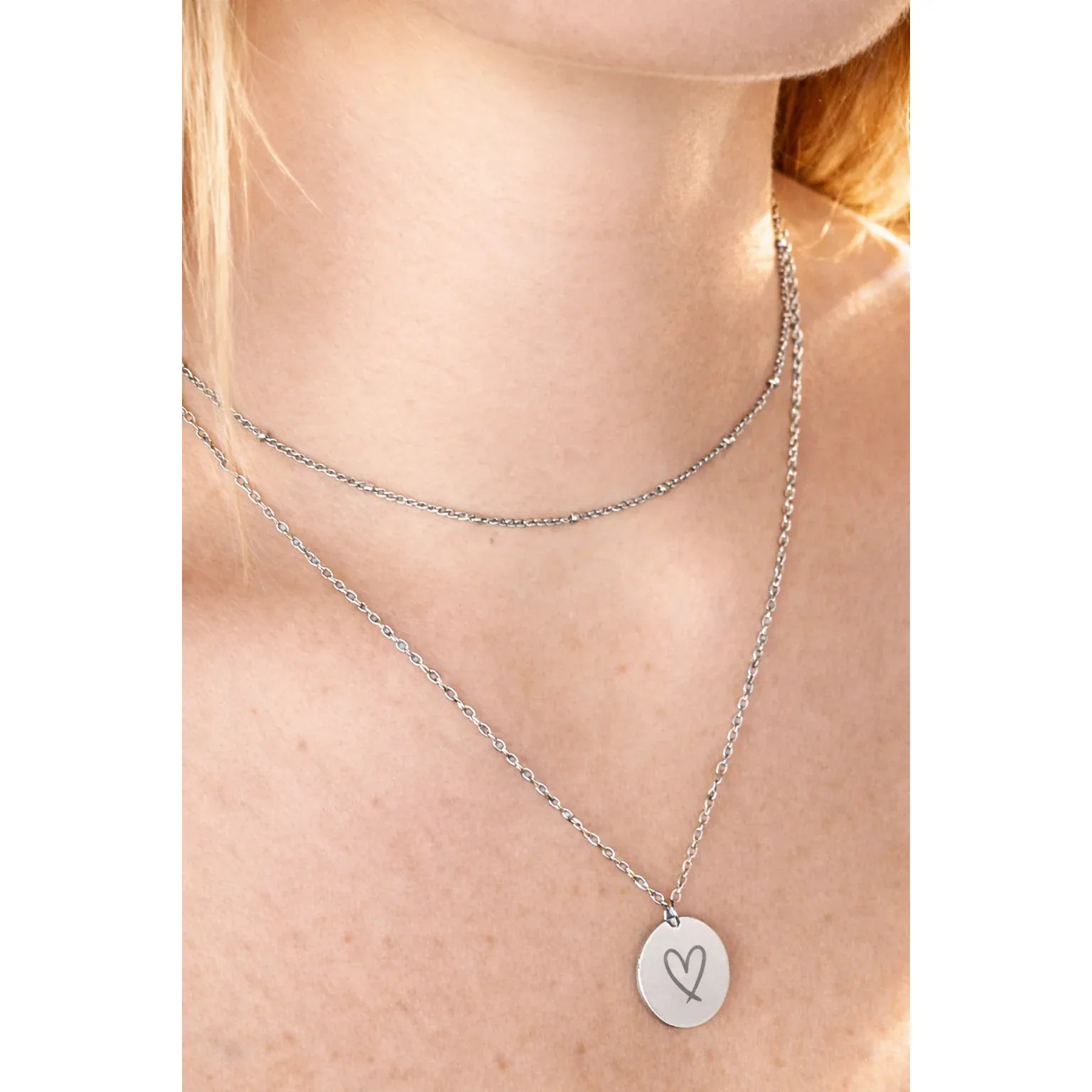 Keep Going Pendant Necklace with engraved circle pendant on layered chains, adjustable 18–20 in.