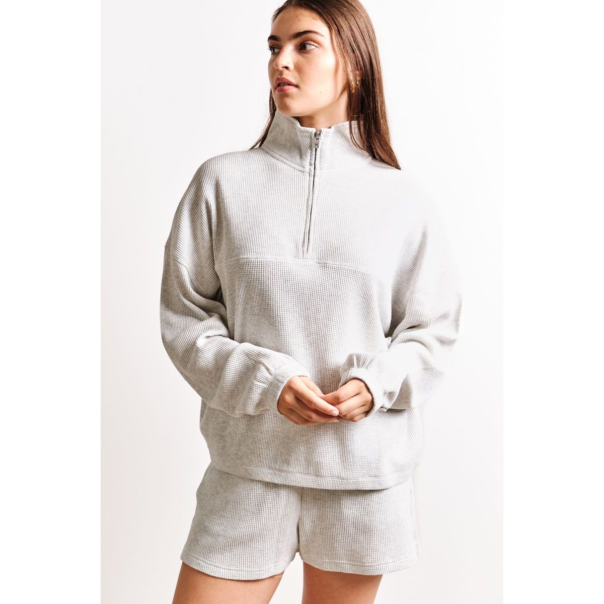 Light gray Kuwalla Bailey Waffle Zip Up on a model; oversized long-sleeve knit with half-zip collar