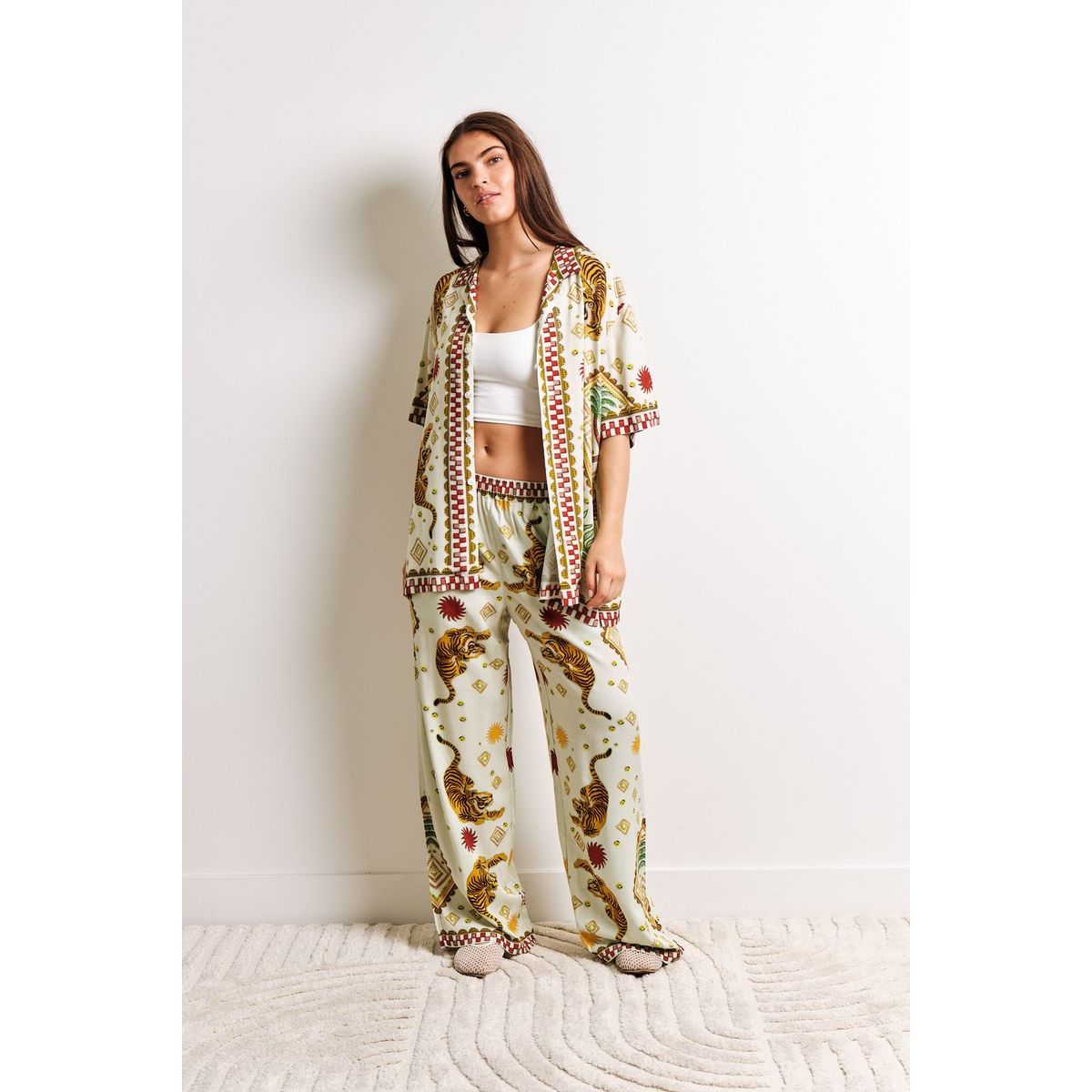 Model wearing Kuwalla Beach Shirt Tiger Cream set with tiger print on cream base, relaxed coastal loungewear.